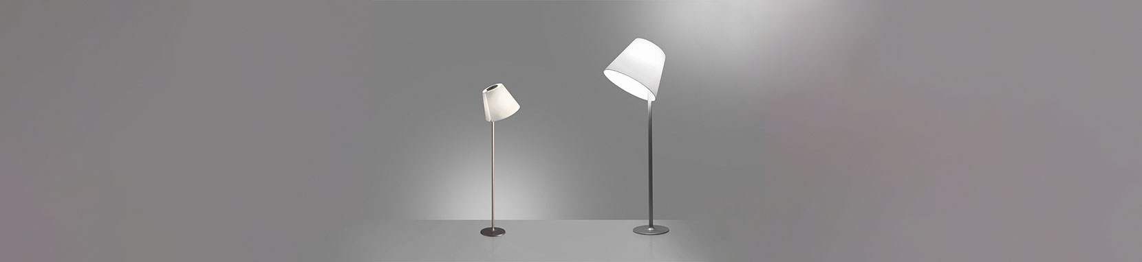 Elegant, klassisch und sehr flexibel – so präsentiert sich Melampo Terra von Artemide. Stab und Sockel präsentieren sich in graulackiertem oder bronzefarbenem Aluminium und harmonisieren perfekt mit dem klassischen Leuchtenschirm aus mit Kunststoff stabilisiertem Seidensatin. Dieser verleiht der Leuchte durch sein besonderes Finish einen zweifachästhetischen Effekt: In ausgeschaltetem Zustand erscheint der Schirm, je nach Farbwahl, Aluminiumgrau oder Ecrú, eingeschaltet erstrahlt er in angenehmem Weiß oder Naturfarben. Die freie Ausrichtbarkeit des Leuchtenschirms in drei Positionen macht Melampo Terra sehr flexibel und vielseitig einsetzbar und ermöglicht es ihr sowohl direktes Licht zum Lesen als auch indirektes gestreutes Licht in den Raum zu spenden. Melampo Terra passt sich den Anforderungen des Nutzers in jeder Situation an. Durch das elegante Design und die angenehme Lichtstimmung verleiht Melampo Terra sowohl privaten als auch geschäftlichen Ambiente eine wohnliche Atmosphäre. (Bitte beachten sie, dass Melampo Terra aus Gründen der Transportsicherheit per Spedition versendet wird). Melampo Terra wurde 1999 mit dem deutschen "Red Dot Design Award" ausgezeichnet.