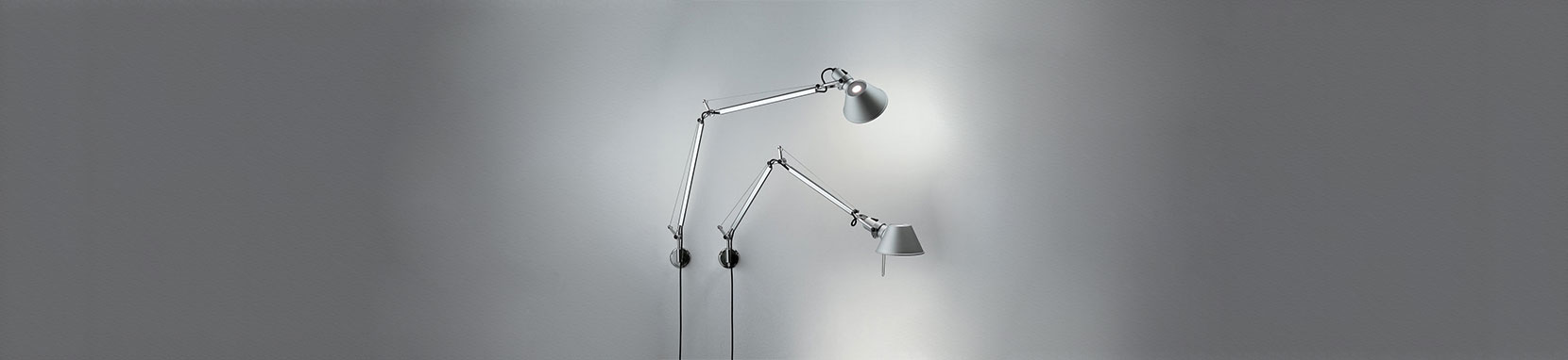 Die Artemide Tolomeo Parete ist die Wandleuchten-Variante der wohl bekanntesten Schreibtischleuchte Tolomeo Tavolo und entstammt der Feder von Michele de Lucchi. Bereits 1987 wurde dieser Designklassiker zeitgemäßer Schreibtischbeleuchtung auf den Markt gebracht. Durch die Wandmontage verlieren Sie auf dem Schreibtisch keinen Platz oder an der Wand im Wohn- oder Schlafzimmer montiert haben Sie Ihr perfektes Leselicht immer griffbereit. Die Leuchtenserie Tolomeo überzeugt mit ihren technischen Eigenschaften und dem komfortabel ausrichtbaren sowie blendfreien Licht. Tolomeo steht für erstklassige Verarbeitung, maximale Flexibilität, beste Lichtqualität und einen enormen Einsatzradius. Dank dieser hervorragenden Eigenschaften und dem zeitlosen Design wurde die Tolomeo zu der vielleicht weltweit verbreitetsten Leuchte im Arbeitsplatzbereich überhaupt und fungiert bereits als Sinnbild für die italienische Designleuchtenfirma Artemide. Michele de Lucchi wurde für diese Leuchte mit internationalen Designpreisen überhäuft und die immer noch andauernde Erfolgsgeschichte der Tolomeo macht dieses Meisterstück unweigerlich zum Lebenswerk des Stardesigners. Das beeindruckende Portfolio der Tolomeo Familie erstreckt sich von der klassischen Schreibtischleuchte über Stehleuchten, Wandleuchten bis hin zu Decken- oder Pendelleuchten und wartet mit verschiedensten Oberflächen und Werkstoffen auf.